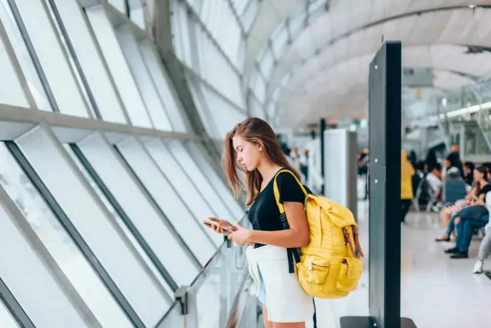 A woman looking at her phone in an airport
